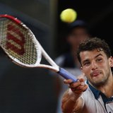 Grigor Dimitrov of Bulgaria returns the ball to Novak Djokovic of Serbia during their men's singles match at the Madrid Open tennis tourname