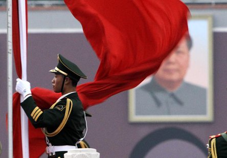 A paramilitary policeman prepares for a national flag-lowering ceremony in front of a portrait of the late chairman Mao Zedong on Tiananmen A paramilitary policeman prepares for a national flag-lowering ceremony in front of a portrait of the late chairman Mao Zedong on Tiananmen