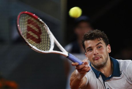 Grigor Dimitrov of Bulgaria returns the ball to Novak Djokovic of Serbia during their men's singles match at the Madrid Open tennis tourname Grigor Dimitrov of Bulgaria returns the ball to Novak Djokovic of Serbia during their men's singles match at the Madrid Open tennis tourname