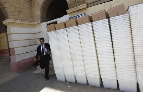 A man walks past rows of election ballot boxes, before they are transported to polling offices, in the premises of the district city court i A man walks past rows of election ballot boxes, before they are transported to polling offices, in the premises of the district city court i