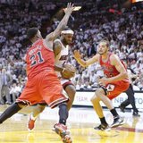 Miami Heat's LeBron James (C) powers past Chicago Bulls' Jimmy Butler (L) and Joakim Noah during Game 2 of their NBA Eastern Conference semi-final basketball playoff in Miami, Florida May 8, 2013. REUTERS/Joe Skipper