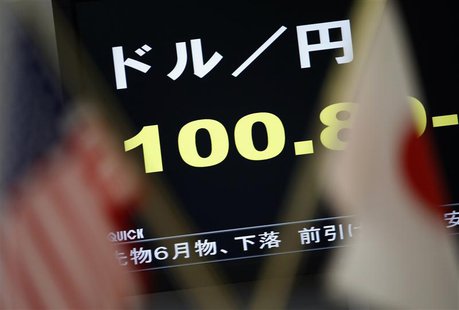 A monitor displaying the Japanese yen's exchange rate against the U.S. dollar is seen between the U.S. (L) and Japanese national flags at a A monitor displaying the Japanese yen's exchange rate against the U.S. dollar is seen between the U.S. (L) and Japanese national flags at a