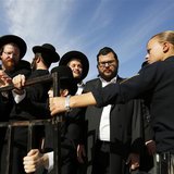 An Israeli policewoman (R) holds back ultra-Orthodox Jewish men as they protest against the "Women of the Wall" group during a monthly praye