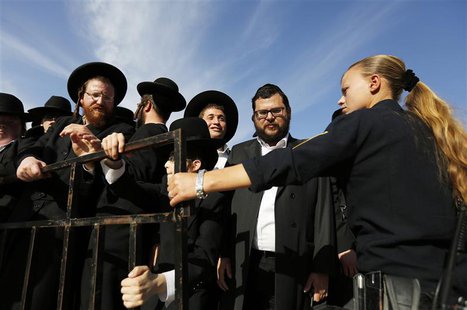 An Israeli policewoman (R) holds back ultra-Orthodox Jewish men as they protest against the "Women of the Wall" group during a monthly praye An Israeli policewoman (R) holds back ultra-Orthodox Jewish men as they protest against the "Women of the Wall" group during a monthly praye