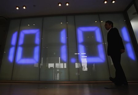 An employee of a foreign exchange company walks past a monitor displaying the Japanese yen's exchange rate against the U.S. dollar in Tokyo An employee of a foreign exchange company walks past a monitor displaying the Japanese yen's exchange rate against the U.S. dollar in Tokyo