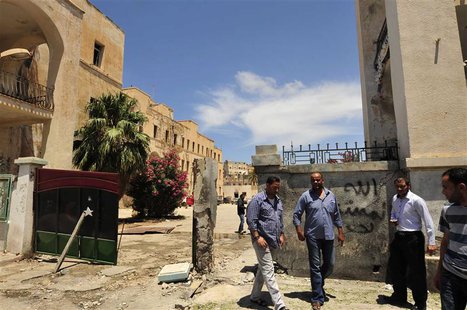Libyans stand next to the scene of a blast after a bomb exploded outside police station in Benghazi May 10, 2013. REUTERS/Esam Al-Fetori Libyans stand next to the scene of a blast after a bomb exploded outside police station in Benghazi May 10, 2013. REUTERS/Esam Al-Fetori