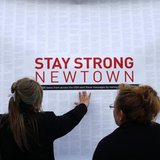 A woman touches a printout of messages from teenagers around the United States at a memorial for the victims of the Sandy Hook Elementary Sc