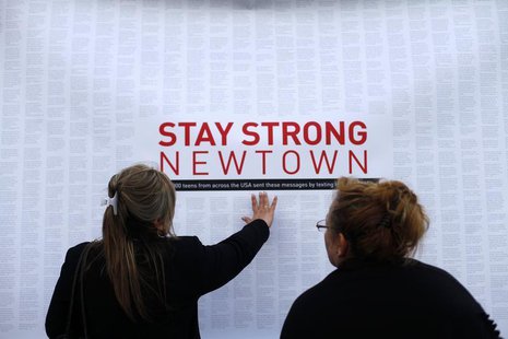 A woman touches a printout of messages from teenagers around the United States at a memorial for the victims of the Sandy Hook Elementary Sc A woman touches a printout of messages from teenagers around the United States at a memorial for the victims of the Sandy Hook Elementary Sc