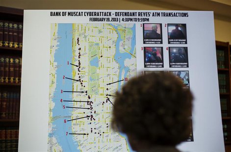 A woman looks at a map showing where eight members belonging to a New York-based cell of a global cyber criminal organization withdrew money A woman looks at a map showing where eight members belonging to a New York-based cell of a global cyber criminal organization withdrew money
