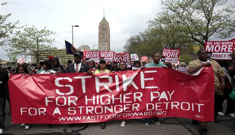 A group of workers and labor activists march down West Grand Boulevard as they demand a raise in the minimum wage for fast food workers in D A group of workers and labor activists march down West Grand Boulevard as they demand a raise in the minimum wage for fast food workers in D