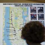 A woman looks at a map showing where eight members belonging to a New York-based cell of a global cyber criminal organization withdrew money A woman looks at a map showing where eight members belonging to a New York-based cell of a global cyber criminal organization withdrew money