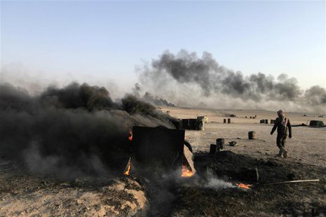 A man walks at a makeshift oil refinery site in al-Mansoura village in Raqqa's countryside May 5, 2013. REUTERS/Hamid Khatib A man walks at a makeshift oil refinery site in al-Mansoura village in Raqqa's countryside May 5, 2013. REUTERS/Hamid Khatib