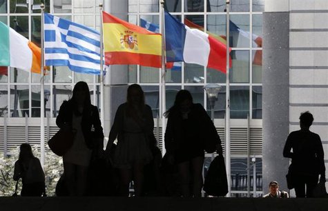 Pedestrians walk towards the (L-R) Irish, Greek, Spanish and French national flags outside the European Parliament in Brussels May 3, 2013. Pedestrians walk towards the (L-R) Irish, Greek, Spanish and French national flags outside the European Parliament in Brussels May 3, 2013.