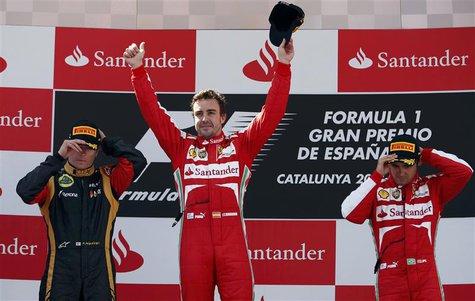 Winner Ferrari Formula One driver Fernando Alonso of Spain (C) celebrates as second-place Lotus Formula One driver Kimi Raikkonen of Finland Winner Ferrari Formula One driver Fernando Alonso of Spain (C) celebrates as second-place Lotus Formula One driver Kimi Raikkonen of Finland