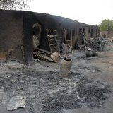 People walk past ashes in the aftermath of what Nigerian authorities said was heavy fighting between security forces and Islamist militants People walk past ashes in the aftermath of what Nigerian authorities said was heavy fighting between security forces and Islamist militants