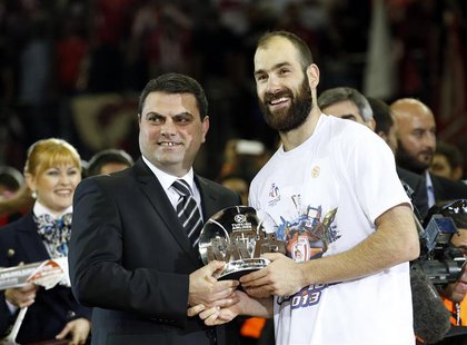 Olympiakos' Vassilis Spanoulis (R) receives the MVP trophy after their Euroleague Basketball Final Four final game against Real Madird at th Olympiakos' Vassilis Spanoulis (R) receives the MVP trophy after their Euroleague Basketball Final Four final game against Real Madird at th