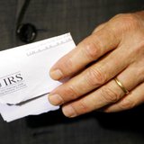 Holding a tax rebate letter from the Internal Revenue Service, U.S. President George W. Bush speaks about the economy during a visit to a sm Holding a tax rebate letter from the Internal Revenue Service, U.S. President George W. Bush speaks about the economy during a visit to a sm