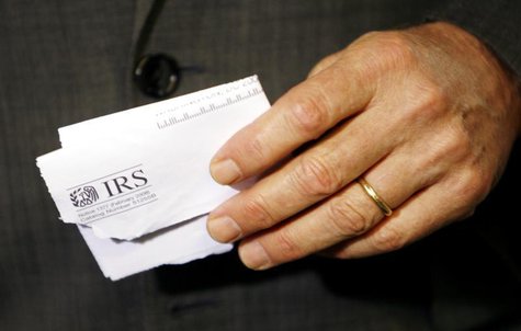 Holding a tax rebate letter from the Internal Revenue Service, U.S. President George W. Bush speaks about the economy during a visit to a sm Holding a tax rebate letter from the Internal Revenue Service, U.S. President George W. Bush speaks about the economy during a visit to a sm