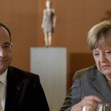 German Chancellor Angela Merkel (R) and French President Francois Hollande arrive for a dinner with representatives of the European Round Ta