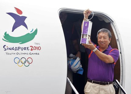 Chairman of the Singapore Youth Olympic Committee Ng Ser Miang arrives with a safety lantern containing the Youth Olympic flame at Changi Ai Chairman of the Singapore Youth Olympic Committee Ng Ser Miang arrives with a safety lantern containing the Youth Olympic flame at Changi Ai