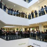 Workers, known as partners at the John Lewis Partnership, celebrate after the announcement of their annual profit related bonus, at their fl