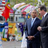 British Prime Minister David Cameron (R) visits a memorial to the victims of the Boston Marathon bombings in Copley Square with Massachusett