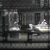 An unidentified prisoner reads a newspaper in a communal cellblock at Camp VI, a prison used to house detainees at Guantanamo Bay U.S. Naval An unidentified prisoner reads a newspaper in a communal cellblock at Camp VI, a prison used to house detainees at Guantanamo Bay U.S. Naval