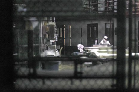 An unidentified prisoner reads a newspaper in a communal cellblock at Camp VI, a prison used to house detainees at Guantanamo Bay U.S. Naval An unidentified prisoner reads a newspaper in a communal cellblock at Camp VI, a prison used to house detainees at Guantanamo Bay U.S. Naval