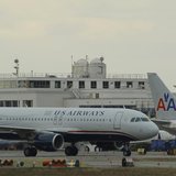 US Airways jets taxi past a parked American Airlines jet (C) at Reagan National Airport in Washington February 28, 2013. REUTERS/Gary Camero US Airways jets taxi past a parked American Airlines jet (C) at Reagan National Airport in Washington February 28, 2013. REUTERS/Gary Camero
