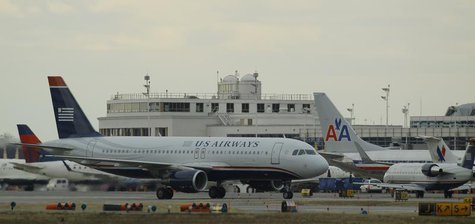 US Airways jets taxi past a parked American Airlines jet (C) at Reagan National Airport in Washington February 28, 2013. REUTERS/Gary Camero US Airways jets taxi past a parked American Airlines jet (C) at Reagan National Airport in Washington February 28, 2013. REUTERS/Gary Camero