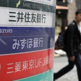 A man walks past a signboard of Japan's three mega banks, Sumitomo Mitsui Banking Corporation (top), Mizuho Bank (C) and Bank of Tokyo-Mitsu A man walks past a signboard of Japan's three mega banks, Sumitomo Mitsui Banking Corporation (top), Mizuho Bank (C) and Bank of Tokyo-Mitsu