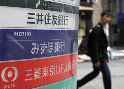 A man walks past a signboard of Japan's three mega banks, Sumitomo Mitsui Banking Corporation (top), Mizuho Bank (C) and Bank of Tokyo-Mitsu A man walks past a signboard of Japan's three mega banks, Sumitomo Mitsui Banking Corporation (top), Mizuho Bank (C) and Bank of Tokyo-Mitsu