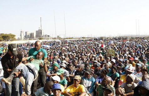An unruly AMCU member (L) is removed from a gathering as other members are addressed by their leaders during a strike at Lonmin's Marikana p An unruly AMCU member (L) is removed from a gathering as other members are addressed by their leaders during a strike at Lonmin's Marikana p