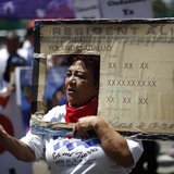 Rosa Ayala carries a Resident Alien placard during the International Workers Day and Immigration Reform March on May Day in Los Angeles, Cal
