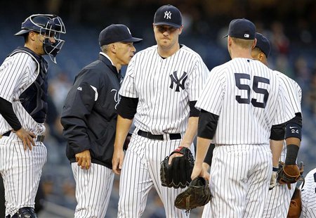 New York Yankees starting pitcher Phil Hughes heads to the dugout after being removed by Yankees manager Joe Girardi during the first inning New York Yankees starting pitcher Phil Hughes heads to the dugout after being removed by Yankees manager Joe Girardi during the first inning