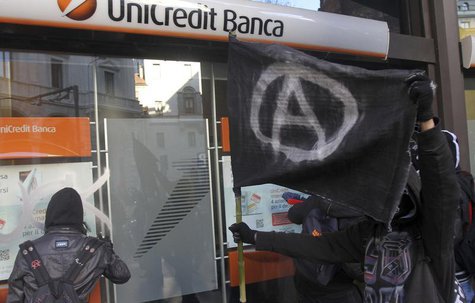 Students paint on the front of a Unicredit bank during a protest against government budget cuts in Milan December 12, 2012. REUTERS/Stringer Students paint on the front of a Unicredit bank during a protest against government budget cuts in Milan December 12, 2012. REUTERS/Stringer