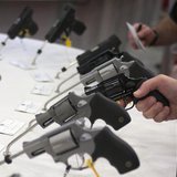 A man holds a gun in the exhibit hall of the George R. Brown Convention Center, the site for the National Rifle Association's (NRA) annual m A man holds a gun in the exhibit hall of the George R. Brown Convention Center, the site for the National Rifle Association's (NRA) annual m