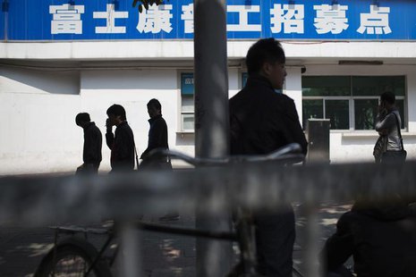 People walk past a closed job centre of Foxconn factory in the township of Longhua in Shenzhen, Guangdong province February 21, 2013. REUTER People walk past a closed job centre of Foxconn factory in the township of Longhua in Shenzhen, Guangdong province February 21, 2013. REUTER