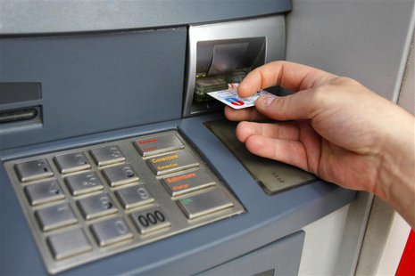 A man uses a traditional automated teller machine (ATM) in Bucharest May 17, 2013. REUTERS/Bogdan Cristel A man uses a traditional automated teller machine (ATM) in Bucharest May 17, 2013. REUTERS/Bogdan Cristel