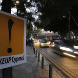 Vehicles speed past a sign placed by anti-Troika protesters outside the parliament in Nicosia March 24, 2013. REUTERS/Yannis Behrakis Vehicles speed past a sign placed by anti-Troika protesters outside the parliament in Nicosia March 24, 2013. REUTERS/Yannis Behrakis
