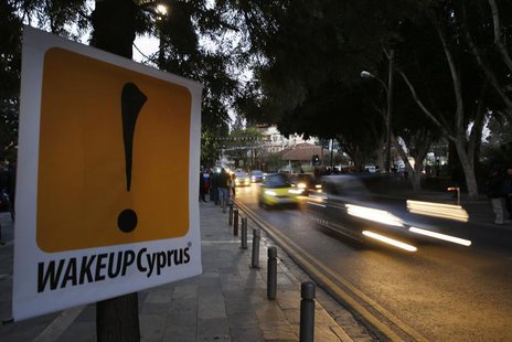 Vehicles speed past a sign placed by anti-Troika protesters outside the parliament in Nicosia March 24, 2013. REUTERS/Yannis Behrakis Vehicles speed past a sign placed by anti-Troika protesters outside the parliament in Nicosia March 24, 2013. REUTERS/Yannis Behrakis