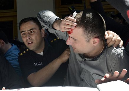 A policeman helps an injured man during clashes at an International Day Against Homophobia and Transphobia (IDAHO) rally in Tbilisi, May 17, A policeman helps an injured man during clashes at an International Day Against Homophobia and Transphobia (IDAHO) rally in Tbilisi, May 17,
