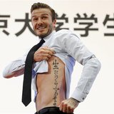 Former England captain David Beckham shows his tattoo after he was asked to by students at Peking University during his visit in Beijing in Former England captain David Beckham shows his tattoo after he was asked to by students at Peking University during his visit in Beijing in