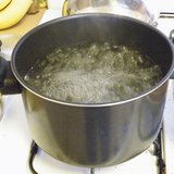 Water boils in a pot on a stove.