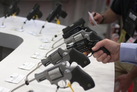 A man holds a gun in the exhibit hall of the George R. Brown Convention Center, the site for the National Rifle Association's (NRA) annual m A man holds a gun in the exhibit hall of the George R. Brown Convention Center, the site for the National Rifle Association's (NRA) annual m