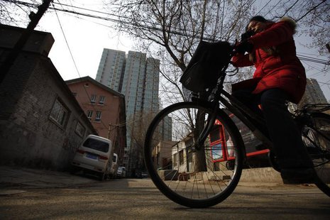 A woman rides her bicycle along an alley next to a residential compound in central Beijing, March 22, 2013. REUTERS/Petar Kujundzic A woman rides her bicycle along an alley next to a residential compound in central Beijing, March 22, 2013. REUTERS/Petar Kujundzic