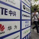 A man walks past an advertisement board showing the logos of Huawei and ZTE on it, outside a mobile phone repair shop in Wuhan October 11, 2 A man walks past an advertisement board showing the logos of Huawei and ZTE on it, outside a mobile phone repair shop in Wuhan October 11, 2