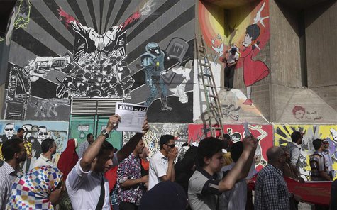 Protesters chant anti-Mursi and anti-Muslim Brotherhood slogans near graffiti during a demonstration in a street leading to Tahrir square, i Protesters chant anti-Mursi and anti-Muslim Brotherhood slogans near graffiti during a demonstration in a street leading to Tahrir square, i