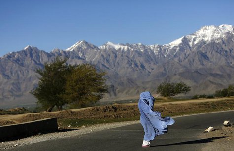 An Afghan woman in a burqa walks along a road on a windy day on the outskirts of Kabul April 16, 2013. REUTERS/Mohammad Ismail An Afghan woman in a burqa walks along a road on a windy day on the outskirts of Kabul April 16, 2013. REUTERS/Mohammad Ismail