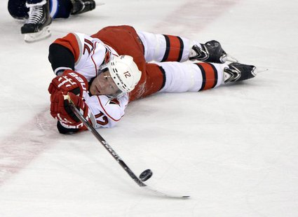 Carolina Hurricanes' Eric Staal (12) passes the puck after falling against the Winnipeg Jets during the first period of their NHL hockey gam Carolina Hurricanes' Eric Staal (12) passes the puck after falling against the Winnipeg Jets during the first period of their NHL hockey gam